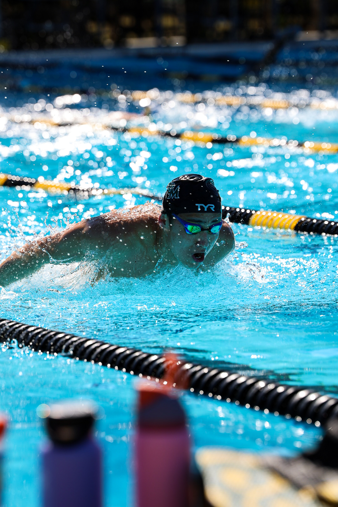 Competing butterfly stroke in outdoor pool